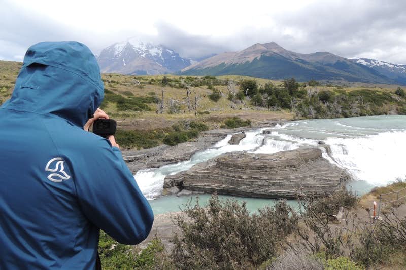 Junge fotografiert den Paine Grande Wasserfall