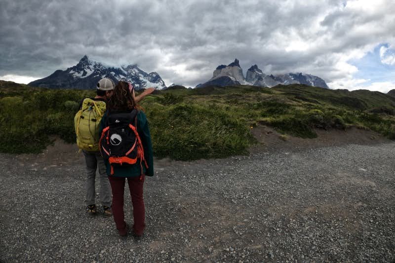 Guide and traveler viewing Cuernos del Paine
